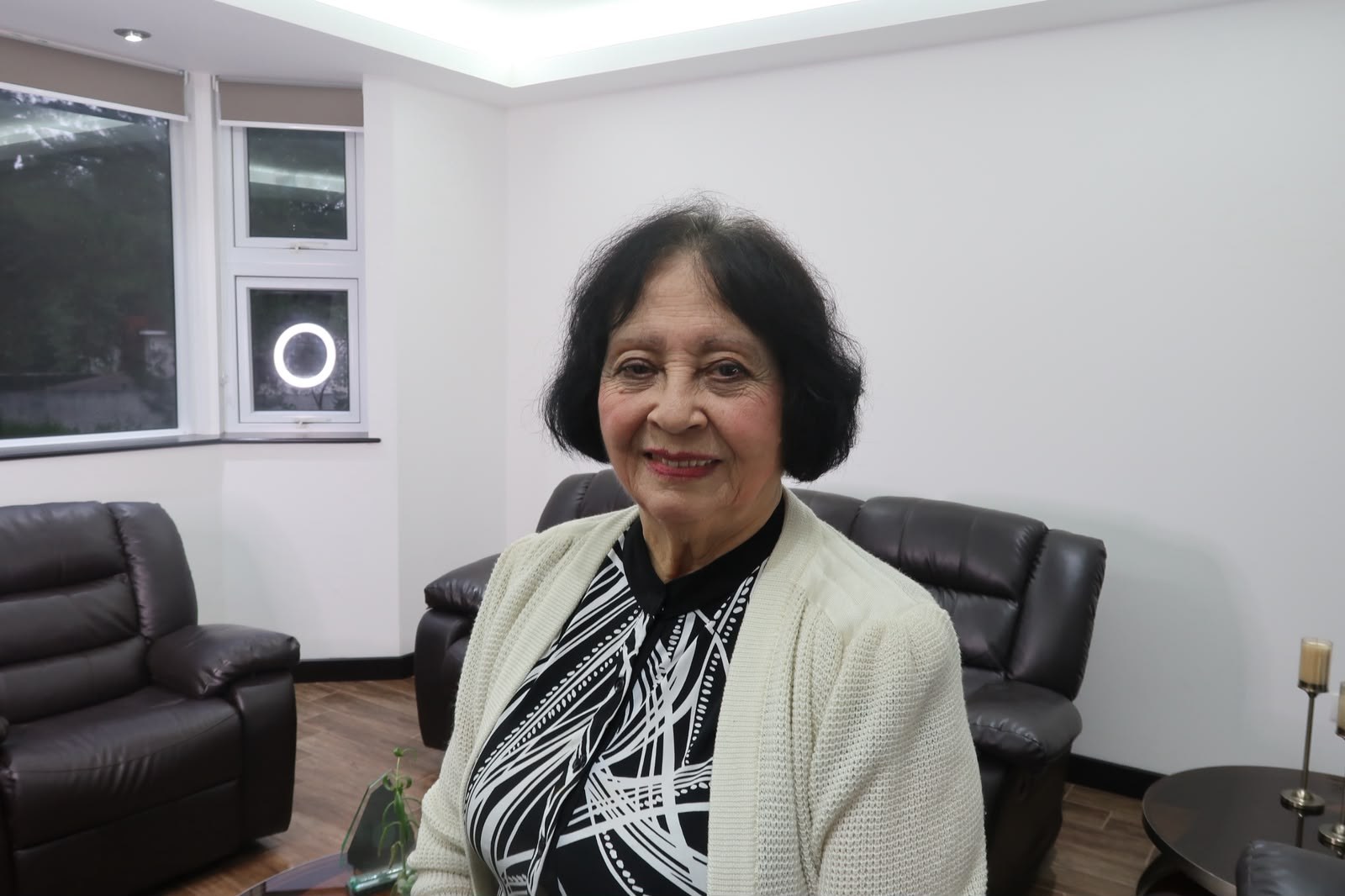 Gladys Bailey sentada en la sala de su casa